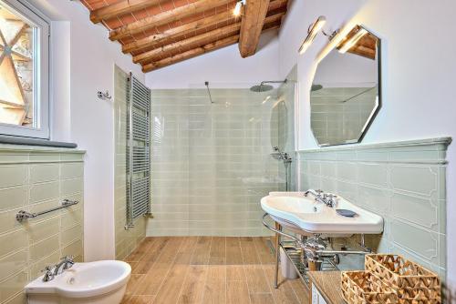 a bathroom with a sink and a toilet and a mirror at Castello Vicchiomaggio in Greve in Chianti