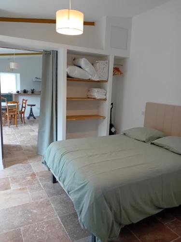 a bedroom with a bed and a room with a table at La petite Maison du Manoir de La Grande Vigne in Mayenne