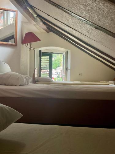 a large bed in a bedroom with a window at Apartments Đukić in Kotor