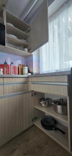 a kitchen with wooden cabinets with pots and pans at Metropolis Apartamenty Centrum in Kalisz