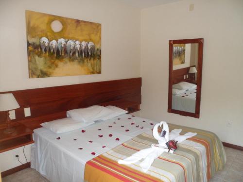 a hotel room with a bed with a bow on it at Pousada Solar das Montanhas in Penedo