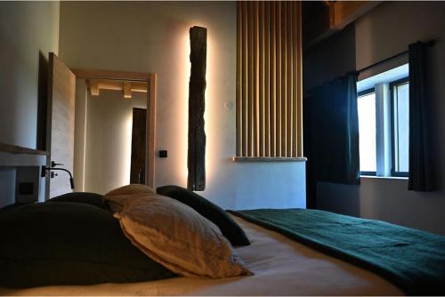 a bedroom with a bed with pillows and a window at La loge de la Dolarde in Prémanon