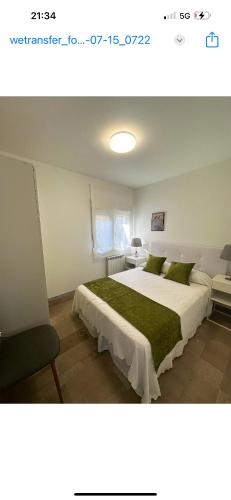 a bedroom with a large white bed with green sheets at Chancelas A in Combarro