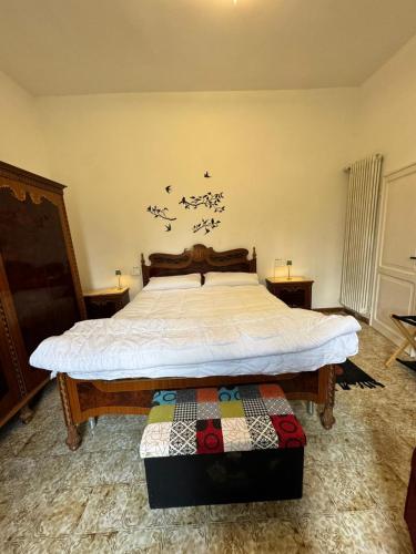 a bedroom with a large bed with white sheets at Appartamento Tenuta Mattei in Vergato