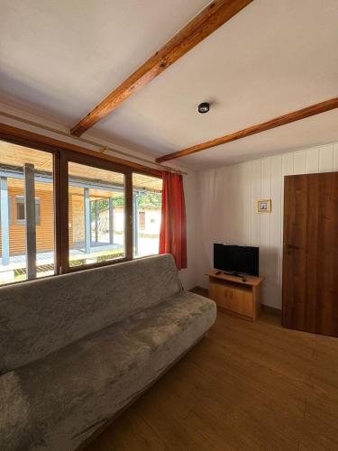 a living room with a couch and a television at Amber Coast domek nr 2 in Jantar