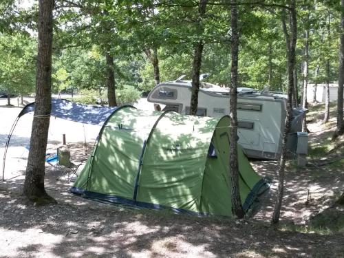 a tent and a trailer in the woods at Camping Village la Verna in Chiusi della Verna