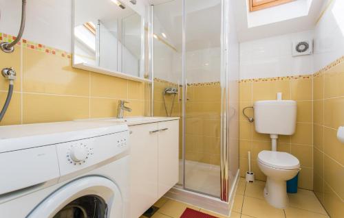 a bathroom with a washing machine and a toilet at Nives in Šilo
