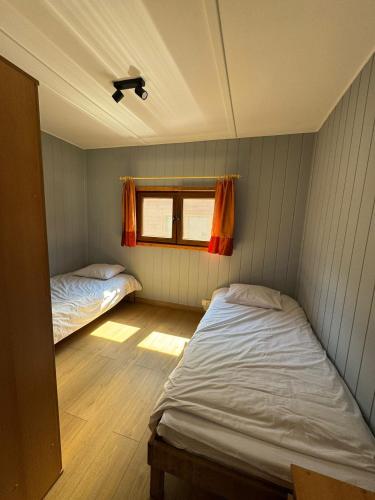 two beds in a small room with a window at Amber Coast domek nr 2 in Jantar