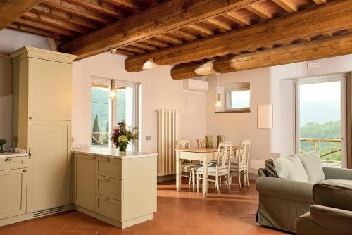 a kitchen and living room with a table and a couch at Castello Vicchiomaggio in Greve in Chianti