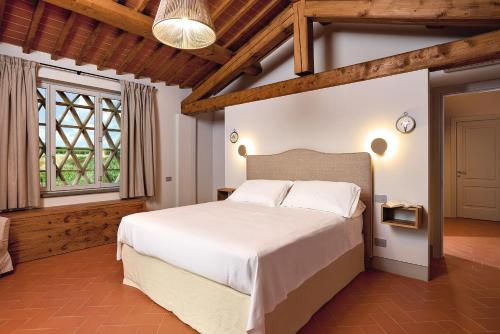 a bedroom with a large white bed in a room at Castello Vicchiomaggio in Greve in Chianti