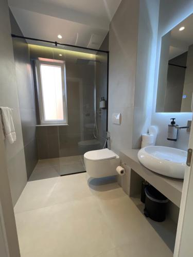a bathroom with a sink and a toilet and a mirror at Mina Luxury Rooms in Tirana