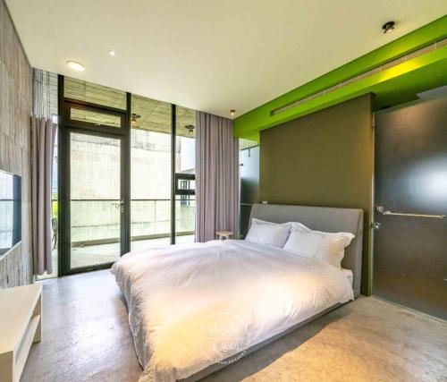 a bedroom with a white bed and a large window at 五月的天空 包棟服務 in Wujie