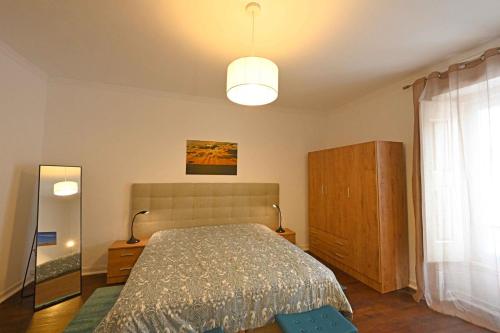 a bedroom with a bed and a large window at Matriz Home in Portel