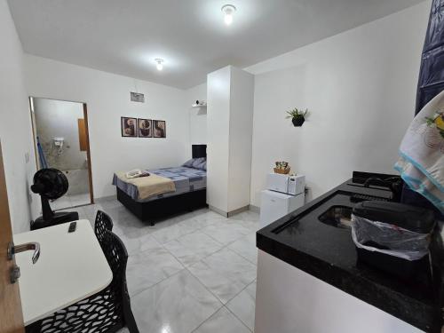 a room with a kitchen and a bedroom with a bed at Flat completo 1 minuto da feira quartas e domingos in Aparecida de Goiania