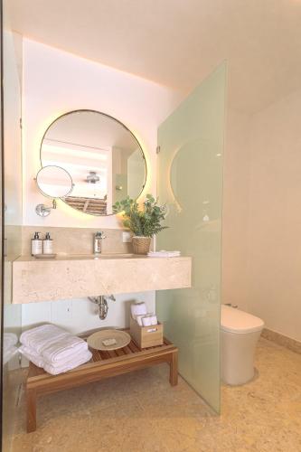 a bathroom with a sink and a mirror and a toilet at Islawa Soy Local - Isla Privada in Baru