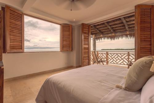 a bedroom with a bed and a large window at Islawa Soy Local - Isla Privada in Baru