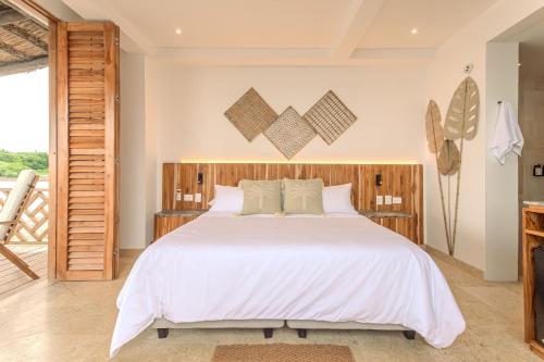 a bedroom with a large bed with white sheets at Islawa Soy Local - Isla Privada in Baru