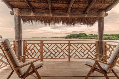 two chairs on a porch with a view of the ocean at Islawa Soy Local - Isla Privada in Baru