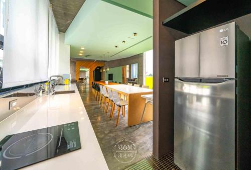 a large kitchen with a counter and a dining area at 五月的天空 包棟服務 in Wujie