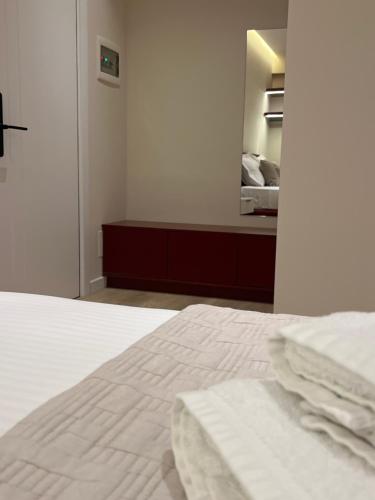 a bedroom with a white bed and a mirror at Mina Luxury Rooms in Tirana