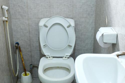 a bathroom with a toilet with the lid up at L&J Modern Backpackers Kinondoni in Dar es Salaam