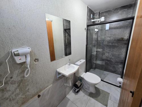 a bathroom with a toilet and a sink and a shower at Flat completo 1 minuto da feira quartas e domingos in Aparecida de Goiania