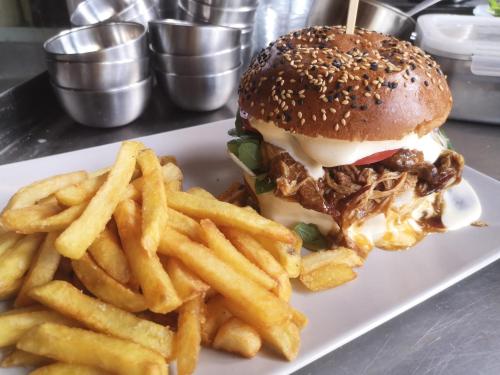 a pulled pork sandwich and french fries on a plate at Penzion Vila Křenov in Bernartice