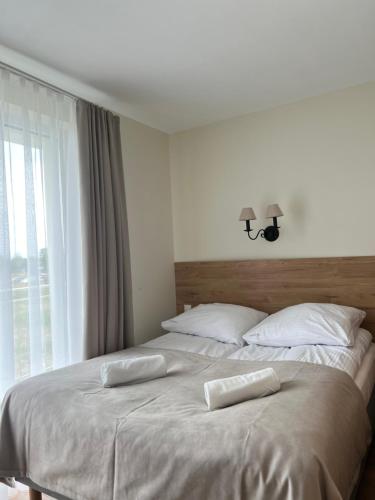 a bedroom with a bed with two pillows on it at Morskie Oko Apartamenty in Ustronie Morskie