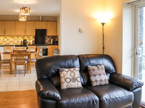 a leather couch in a living room with a kitchen at Berwyn - Uk48507 in Bala