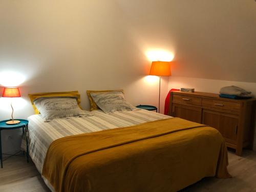 a bedroom with a large bed with two lamps at Ecrin de Verdure in Sainte-Suzanne