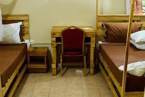 a room with two bunk beds and a chair at L&J Modern Backpackers Kinondoni in Dar es Salaam