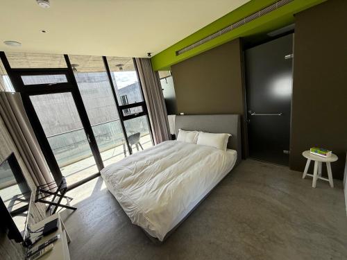 a bedroom with a bed and a large window at 五月的天空 包棟服務 in Wujie