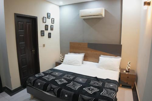 a bedroom with a bed with a black and white comforter at Perfect Place for Family in Lahore in Lahore