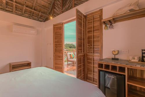 a bedroom with a bed and a fireplace and a window at Islawa Soy Local - Isla Privada in Baru