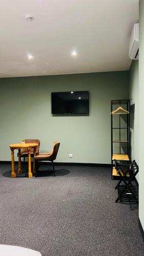 a room with a table and a chair and a television at Estremoz Hotel in Estremoz
