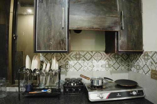 a kitchen counter with a stove and some utensils at Perfect Place for Family in Lahore in Lahore