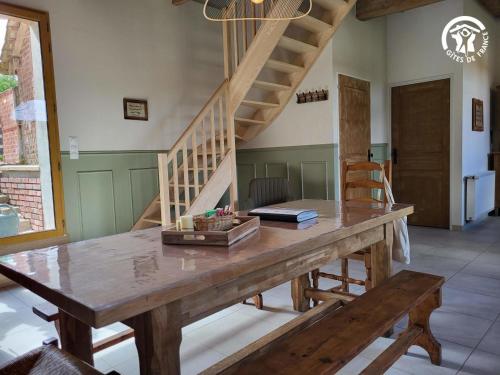 a dining room with a wooden table and stairs at Chambre d'hôtes à la Ferme de la Porte en Aix pour 5 in Aix-en-Issart
