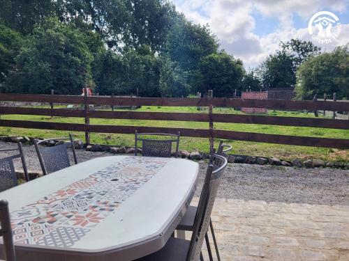 a table and chairs in front of a field at Chambre d'hôtes à la Ferme de la Porte en Aix pour 5 in Aix-en-Issart
