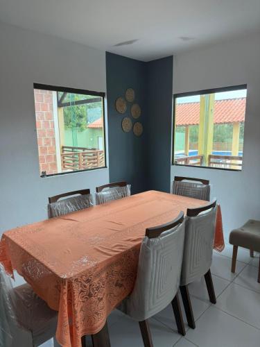 a dining room with a orange table and chairs at Aconchegante Casa em Gravatá - Casa 05 in Gravatá