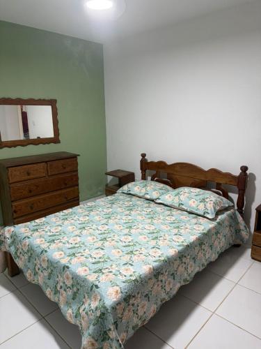 a bedroom with a bed with a dresser and a mirror at Aconchegante Casa em Gravatá - Casa 05 in Gravatá