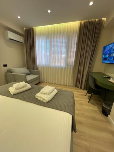 a hotel room with a bed and a desk at Mina Luxury Rooms in Tirana