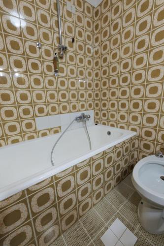 a bathroom with a bath tub and a toilet at Hotel Teola in Livigno