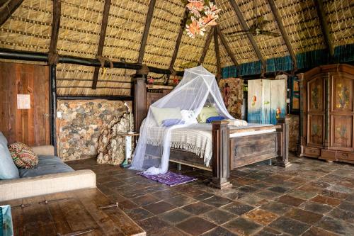 a bedroom with a bed with a mosquito net at Casa El Paraiso, Eco Lodge in Santa Bárbara de Samaná