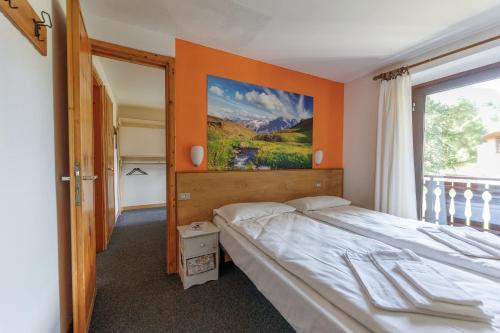 a bedroom with a bed and a painting on the wall at Hotel Teola in Livigno
