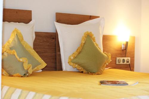 two pillows sitting on top of a bed at Hotel Restaurant Le Petit Kohlberg in Lucelle