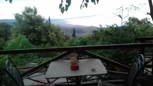 a table with a vase sitting on top of a balcony at Iliovolo Guesthouse in Miléai