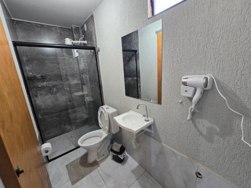 a bathroom with a toilet and a sink and a shower at Flat completo 2 minutos da feira domingo e quarta in Aparecida de Goiania