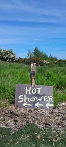 a sign that says not showers in a field at Fairy Hill at Rosemount Glamping in Carlingford