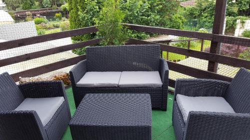 two wicker chairs and tables on a balcony at Zimmer Müller in Wesseling