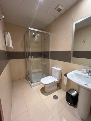 a bathroom with a shower and a toilet and a sink at Hostal Aeropuerto in Madrid